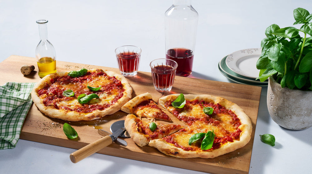 Pasta mit Tomatensauce, Rucola und Gewürzen, serviert auf gelbem Hintergrund